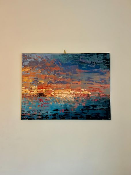 Abstract painting of a vibrant sunset over water with blue and orange hues.